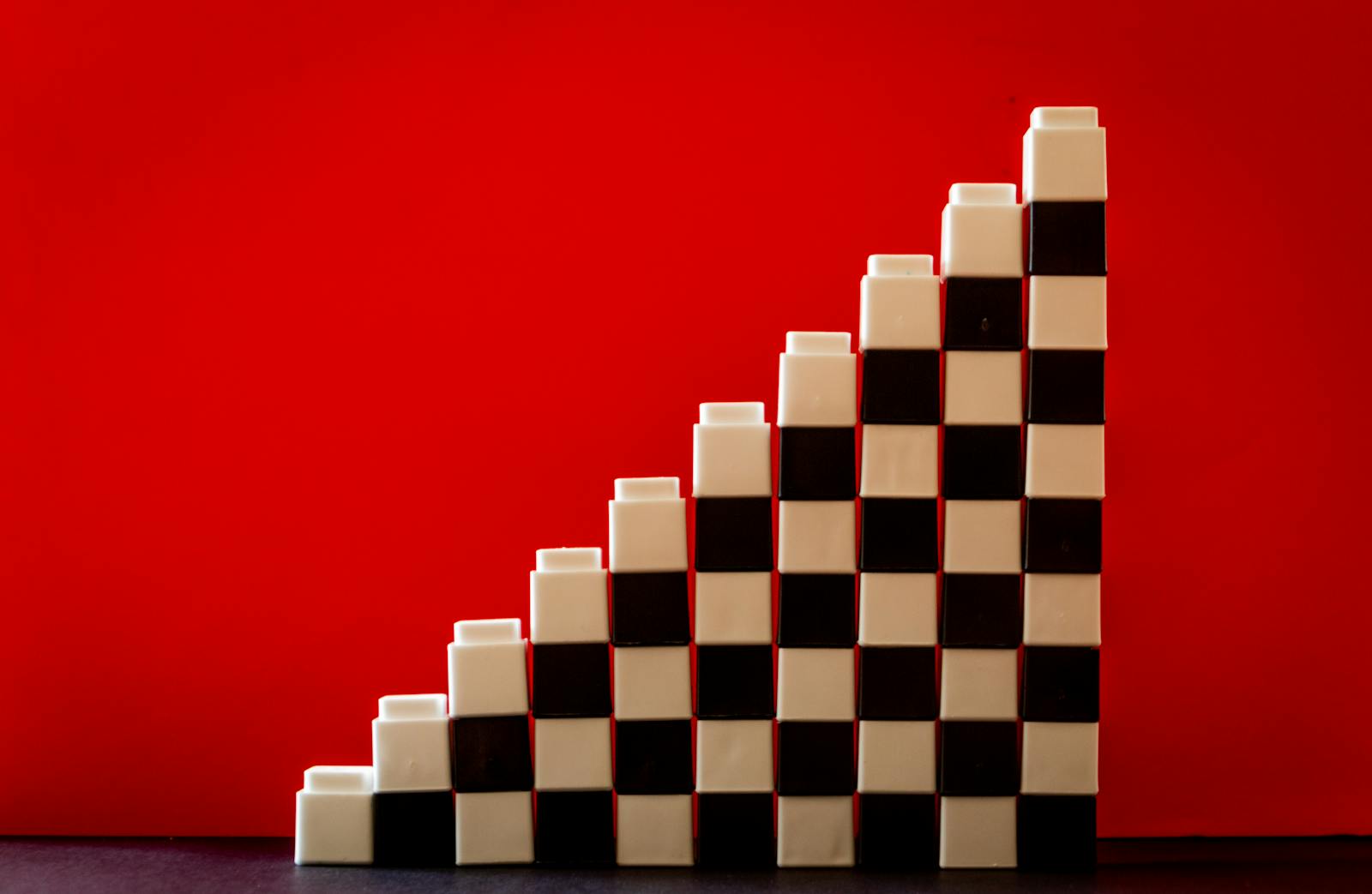 Checkered pattern blocks arranged in a stair formation against a vivid red backdrop.