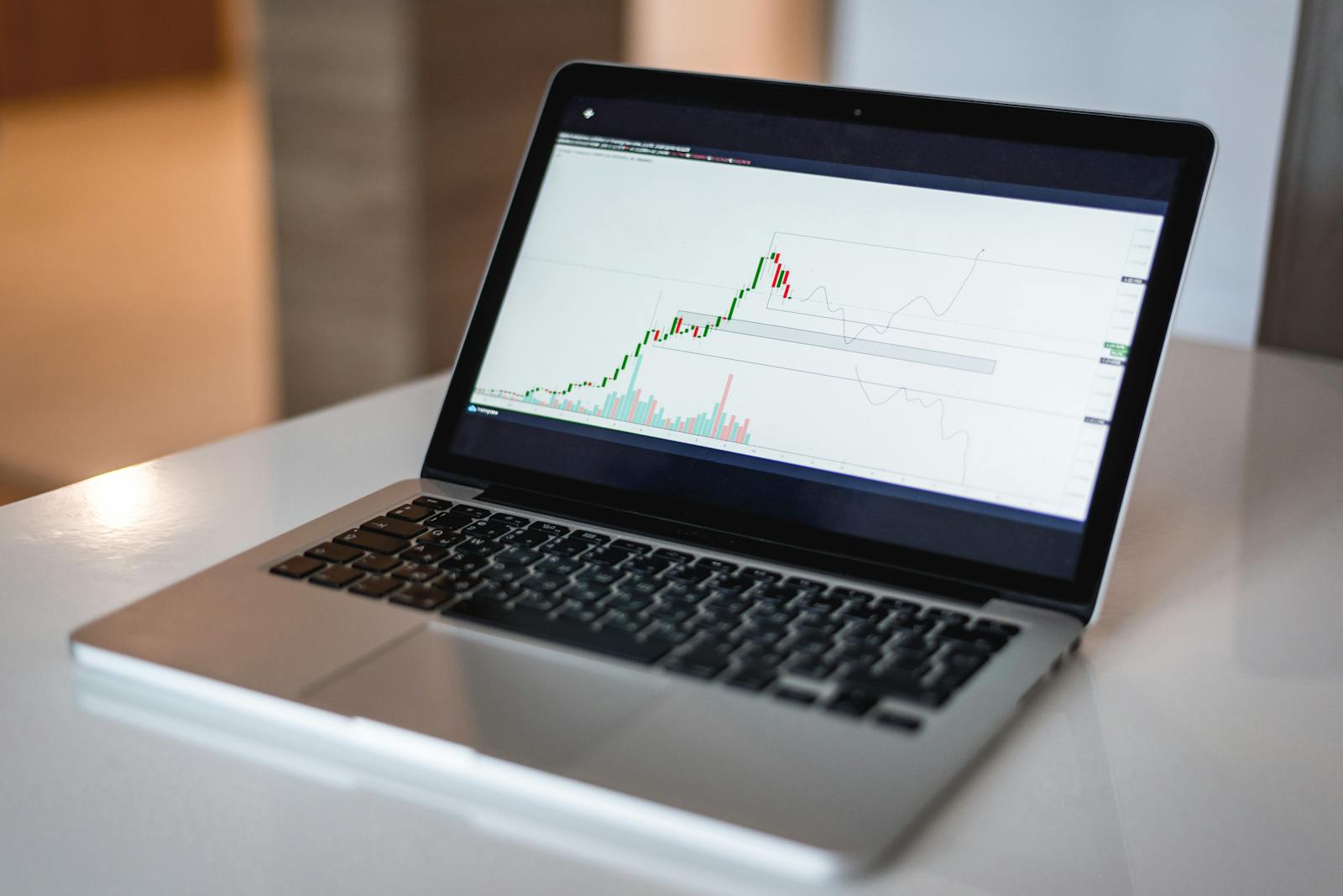 Close-up of a laptop showing a financial trading graph, ideal for finance and technology themes.