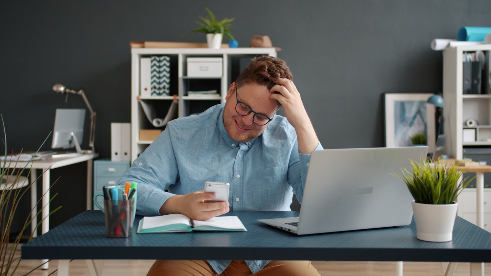 Man looking at phone with hand in hair.
