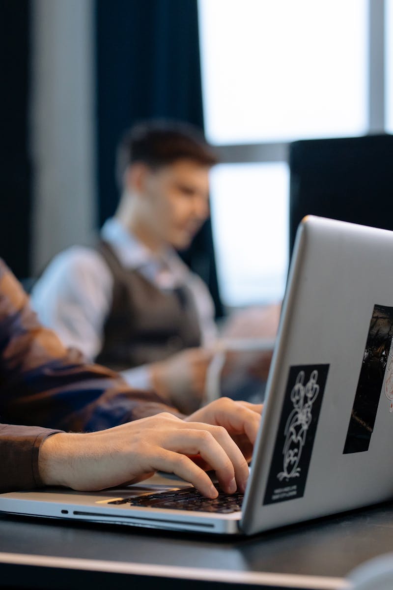 A professional working on a laptop in a contemporary office setting, focused on technology and productivity.